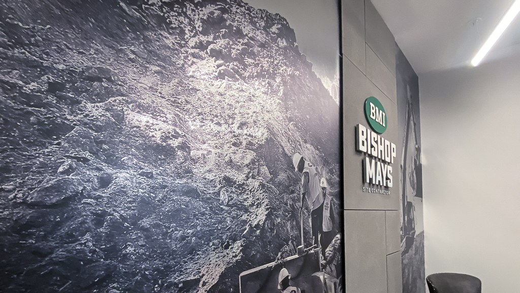 Wall mural vinyl graphic applied to a wall with dimensional signage.